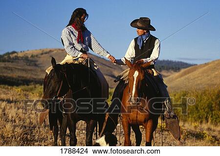 Picture - Cowboy and cowgirl on horseback. Fotosearch