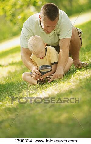Father and son looking through magnifying glass View Large Photo Image Picture - Father and son looking through magnifying glass. Fotosearch