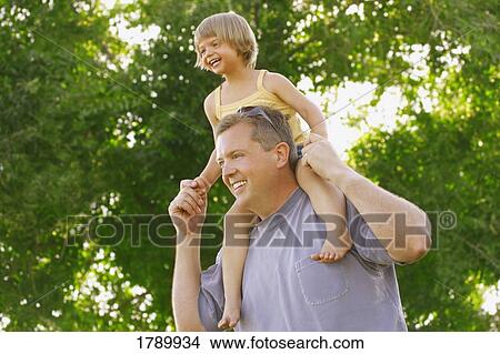 Picture - Father giving his daughter a shoulder ride. Fotosearch