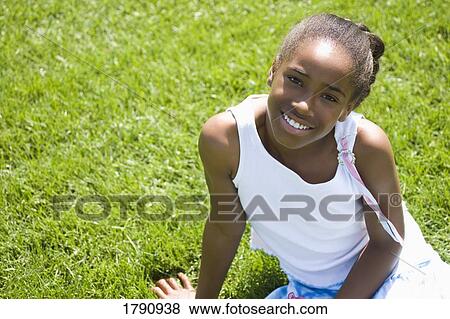 Girl sitting on grass View Large Photo Image Stock Photo - Girl sitting on grass. Fotosearch