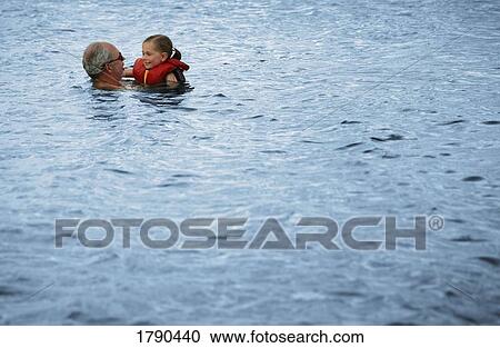 Stock Image - Grandparent swimming with grandchild. Fotosearch