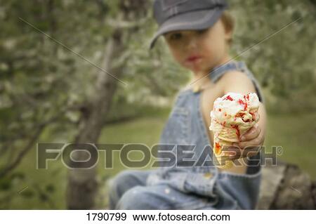 Ice cream cone in the hands of a little boy View Large Photo Image Stock Photo - Ice cream cone in the hands of a little boy. Fotosearch