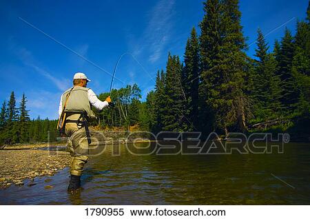 Man fly fishing in a river View Large Photo Image Stock Photography - Man fly fishing in a river. Fotosearch