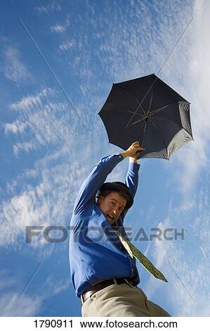 Man holding umbrella floating up into the sky View Large Photo Image Stock Image - Man holding umbrella floating up into the sky. Fotosearch