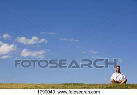 Stock Image - Man meditating outdoors. Fotosearch