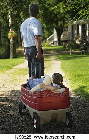 Stock Photo - Man pulling girl in red wagon. Fotosearch