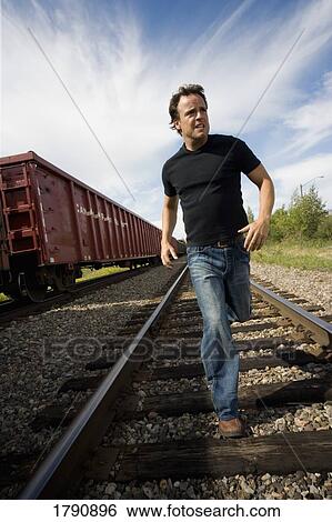 Man running on railroad tracks View Large Photo Image Stock Photograph - Man running on railroad tracks. Fotosearch