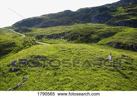 Man walking on hillside View Large Photo Image Stock Photography - Man walking on hillside. Fotosearch