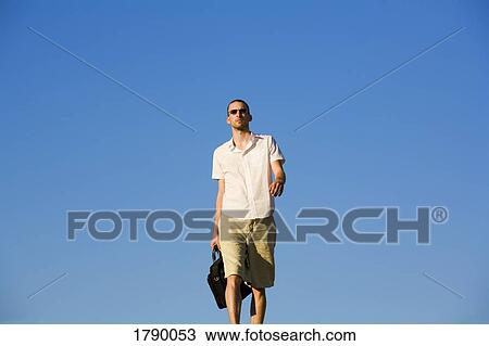 Man walking with a case View Large Photo Image Stock Image - Man walking with a case. Fotosearch