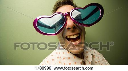 Man wearing large, heart-shaped eye glasses View Large Photo Image Stock Photo - Man wearing large, heart-shaped eye glasses. Fotosearch