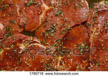 Stock Photo - Marinating rib-eye steaks. Fotosearch