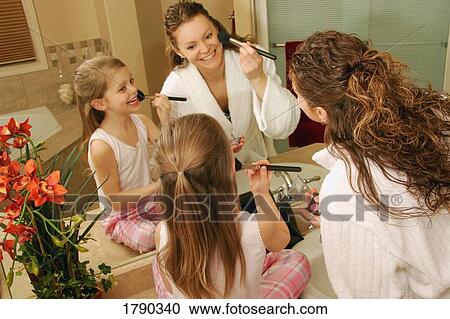 Stock Image - Mother and daughter putting on makeup. Fotosearch