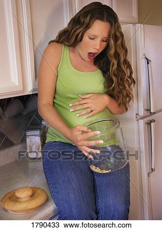 Pregnant woman finishes jar of cookies View Large Photo Image Stock Image - Pregnant woman finishes jar of cookies. Fotosearch