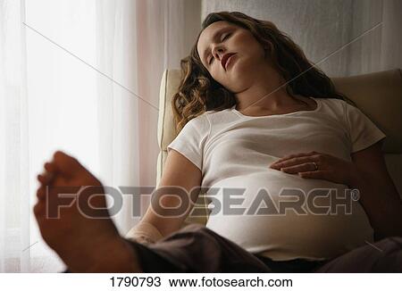 Stock Image - Pregnant woman having afternoon nap. Fotosearch
