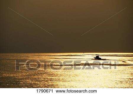 Stock Image - Silhouetted fishing boat on Lake Ontario, New York. Fotosearch