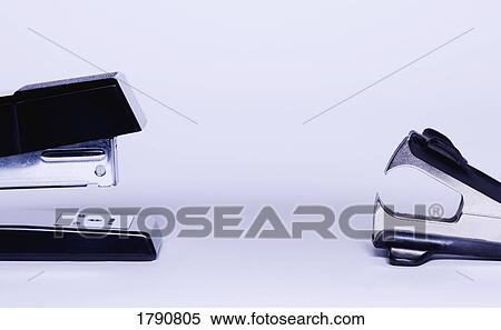 Stock Photography - Stapler versus stapler remover. Fotosearch
