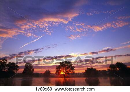 Sunset over still water View Large Photo Image Stock Photo - Sunset over still water. Fotosearch