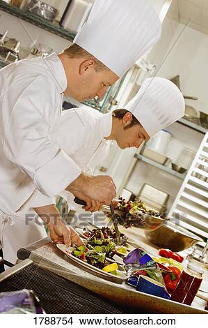 Picture - Two chefs preparing food. Fotosearch