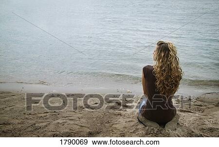 Woman kneeling on shore View Large Photo Image Stock Photo - Woman kneeling on shore. Fotosearch