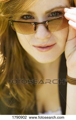 Woman looking over sunglasses View Large Photo Image Stock Image - Woman looking over sunglasses. Fotosearch