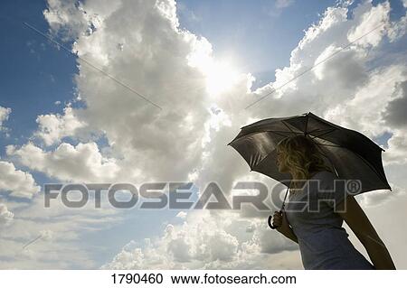 Woman shading herself from the sun View Large Photo Image Stock Image - Woman shading herself from the sun. Fotosearch