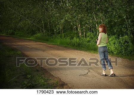 Woman walking down pathway View Large Photo Image Stock Image - Woman walking down pathway. Fotosearch