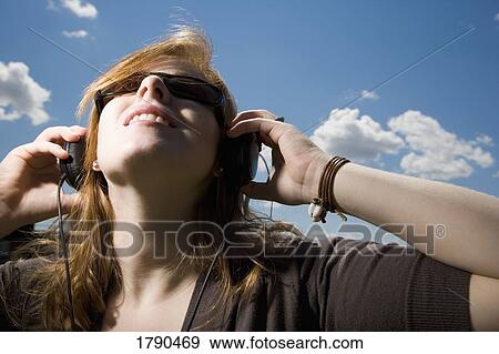 Woman with sunglasses and earphones View Large Photo Image Stock Photo - Woman with sunglasses and earphones. Fotosearch