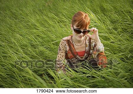 Woman with sunglasses in field of grass View Large Photo Image Picture - Woman with sunglasses in field of grass. Fotosearch