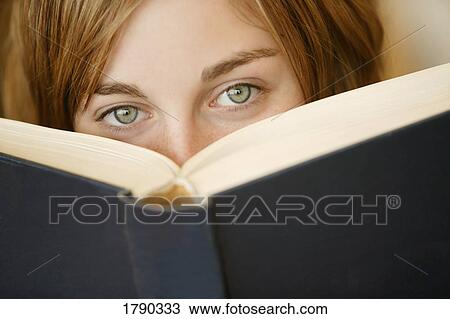 Stock Image - Young girl looking over book. Fotosearch