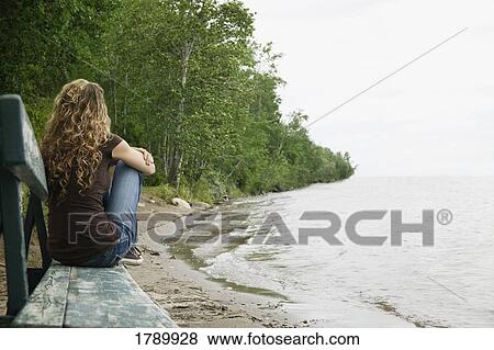 Young lady on bench at beach View Large Photo Image Stock Photo - Young lady on bench at beach. Fotosearch