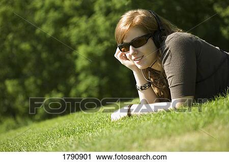 Stock Image - Young woman listening to music. Fotosearch