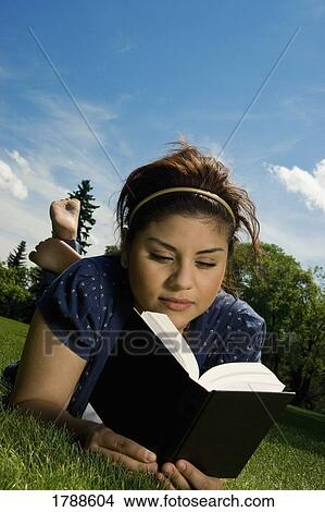 Young woman reading a book outside View Large Photo Image Picture - Young woman reading a book outside. Fotosearch