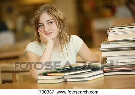 Young woman reading in library View Large Photo Image Stock Photo - Young woman reading in library. Fotosearch