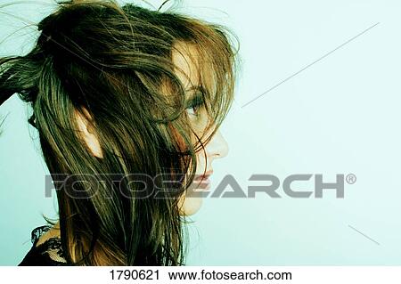 Stock Image - Young woman with wind-blown hair. Fotosearch