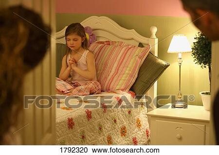 Child praying as parents look on View Large Photo Image Stock Image - Child praying as parents look on. Fotosearch