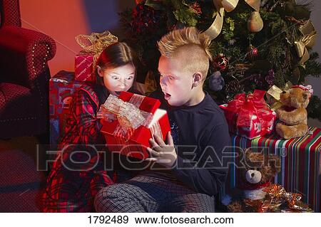 Stock Photo - Children opening Christmas presents. Fotosearch