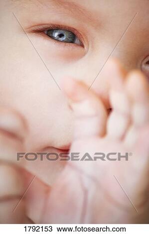Stock Image - Closeup of baby's face and hands. Fotosearch