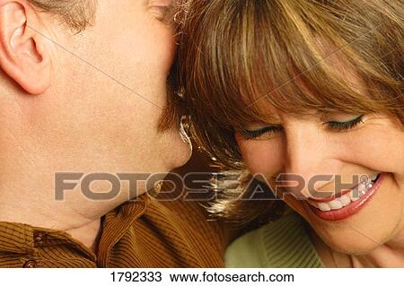 Couple sharing secrets View Large Photo Image Stock Image - Couple sharing secrets. Fotosearch