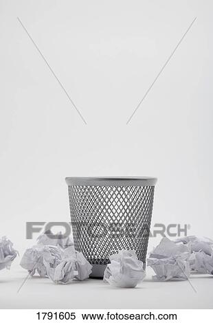 Stock Photography - Crumpled paper on floor around garbage can. Fotosearch