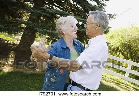 Stock Image - Elderly couple dancing outside. Fotosearch