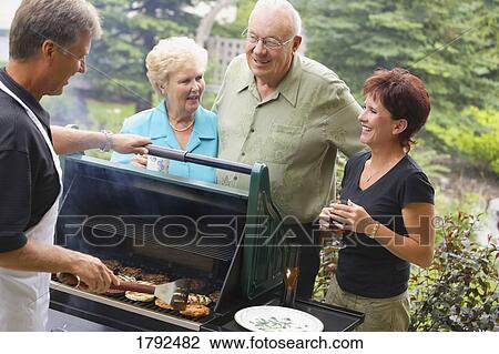 Friends enjoying a BBQ View Large Photo Image Stock Image - Friends enjoying a BBQ. Fotosearch