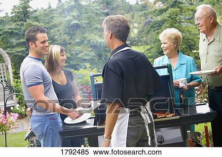 Friends enjoying a BBQ View Large Photo Image Stock Photography - Friends enjoying a BBQ. Fotosearch