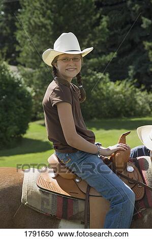 Stock Image - Girl horseback riding. Fotosearch