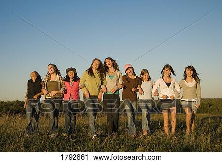 Girls and young women arm-in-arm in field View Large Photo Image Stock Image - Girls and young women arm-in-arm in field. Fotosearch