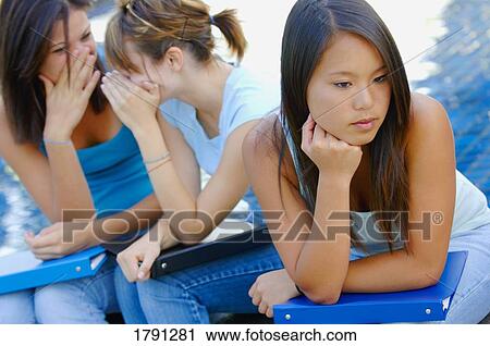 Stock Image - Girls talking about another girl. Fotosearch