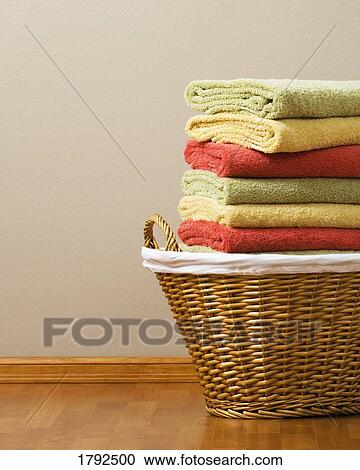 Stock Image - Laundry basket with folded towels. Fotosearch
