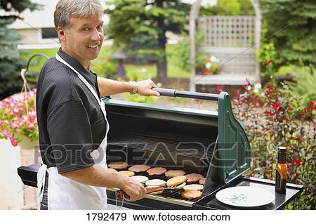 Man barbecuing burgers View Large Photo Image Stock Photo - Man barbecuing burgers. Fotosearch