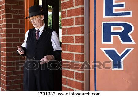 Man in doorway of building looking at watch View Large Photo Image Stock Image - Man in doorway of building looking at watch. Fotosearch