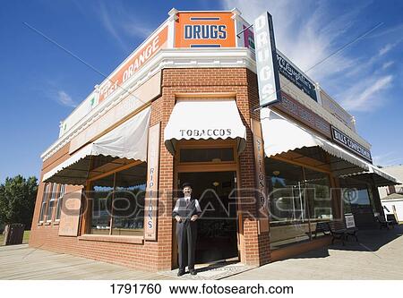 Man in front of historical drugstore View Large Photo Image Stock Image - Man in front of historical drugstore. Fotosearch