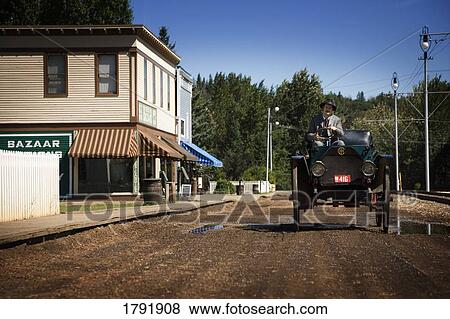 Man in period costume driving a vintage car View Large Photo Image Stock Photo - Man in period costume driving a vintage car. Fotosearch